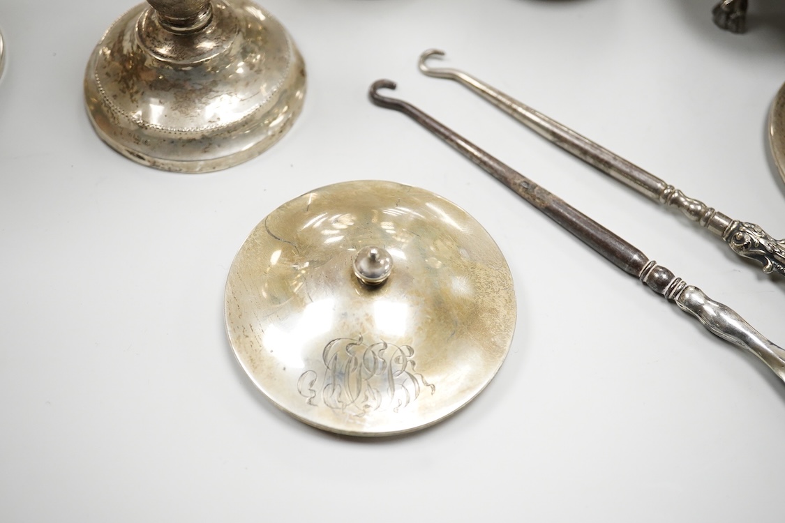An early 20th century silver mounted cut glass scent bottle, five silver mounted glass toilet jars, a pair of silver mounted dwarf candlesticks, two silver condiments, a sterling jug(weighted), a sterling cup and cover(w